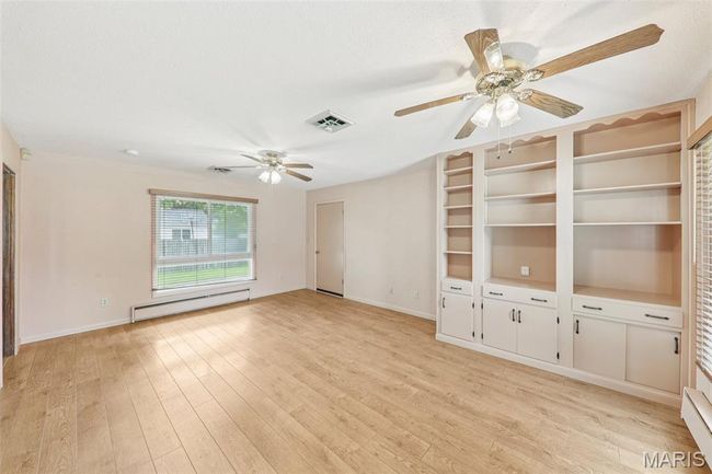 Unfurnished room featuring a baseboard radiator, ceiling fan, and light wood-type flooring | Image 17