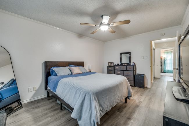 Bedroom featuring crown molding, a textured ceiling, and light hardwood / wood-style flooring | Image 7