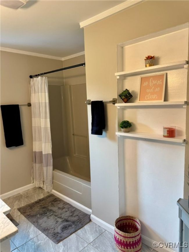 Full bath with crown molding, shower / bath combo with shower curtain, baseboards, and vanity | Image 11