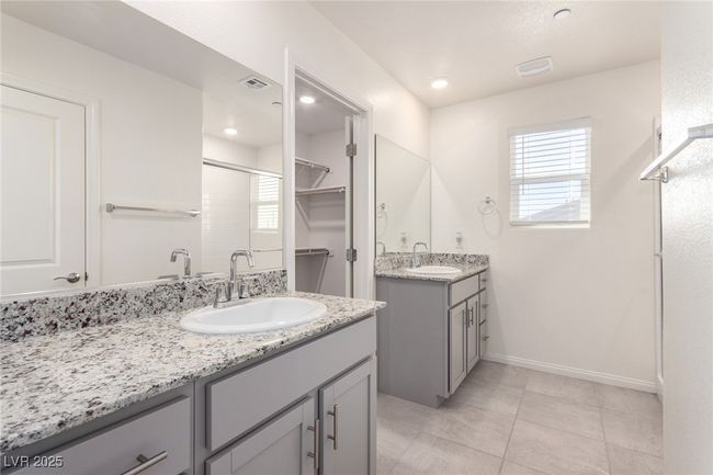 Full bathroom featuring a shower stall, two vanities, a sink, and visible vents | Image 16