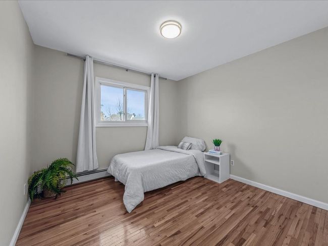 Bedroom with baseboards, wood finished floors, and baseboard heating | Image 19