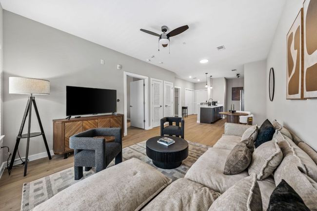 Living room featuring baseboards, visible vents, light wood finished floors, and ceiling fan | Image 15