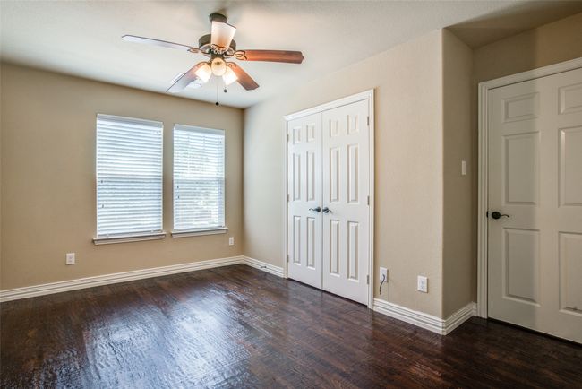 Unfurnished bedroom featuring dark wood finished floors, a closet, and baseboards | Image 8