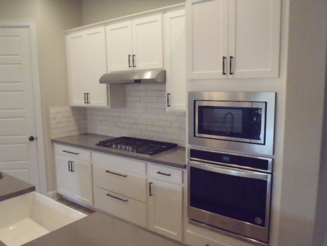 Kitchen with appliances with stainless steel finishes, under cabinet range hood, white cabinetry, and decorative​​‌​​​​‌​​‌‌​‌‌​​​‌‌​​‌‌​‌​​​​​‌ backsplash | Image 15