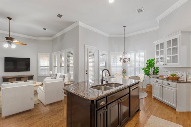 Kitchen featuring a sink, stainless steel dishwasher, ceiling fan, light wood-style floors, and white cabinets VIRTUALLY STAGED | Image 16