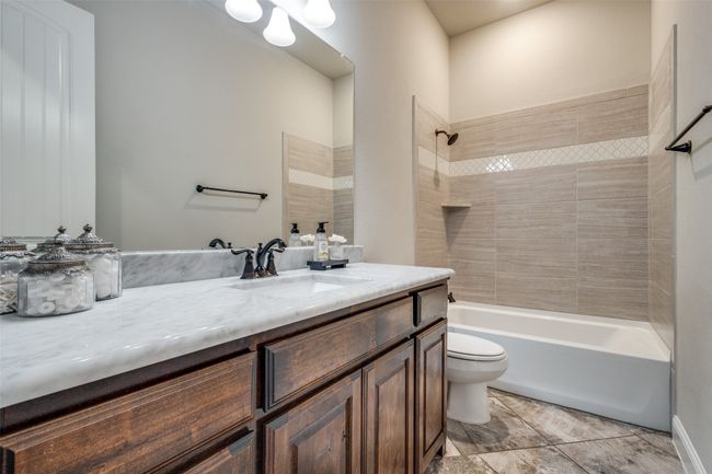 Full bathroom featuring vanity, toilet, and tiled shower / bath | Image 23