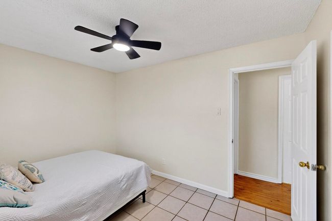 Bedroom featuring light tile patterned floors, a ceiling fan, and a textured ceiling | Image 17