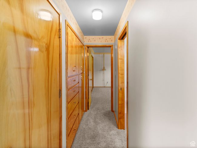 Hall featuring light carpet and custom cabinets | Image 19