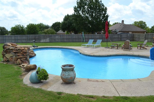 View of swimming pool featuring a patio and a fenced backyard | Image 36