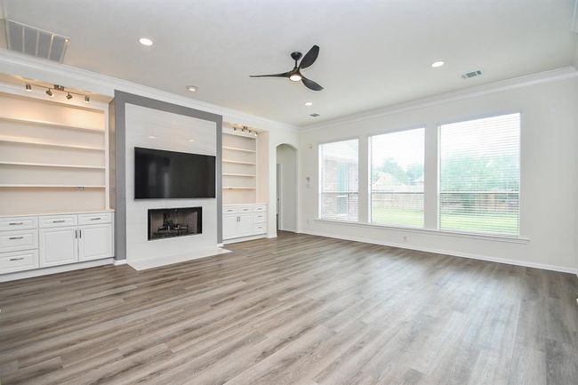 Gather around your beautifully remodeled fireplace (2021), featuring a sleek modern mantle perfect for displaying cherished family photos and hanging holiday stockings and flanked by custom-built solid wood shelves. The television above the fireplace that can be connected to a wired surround sound system to the adjacent cabinet that can store sound system equipment for maximum fun karaoke/movie night experience. Let me lead you to your resting quarters, the primary bedroom. | Image 15