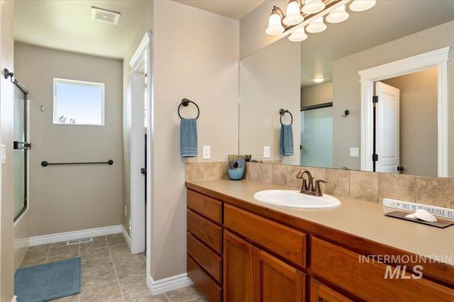 Full bathroom featuring vanity, a chandelier, tile patterned flooring, and combined bath / shower with glass door | Image 13