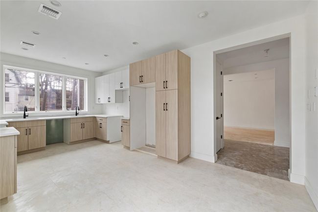 Kitchen featuring visible vents, light brown cabinets, and a sink | Image 18
