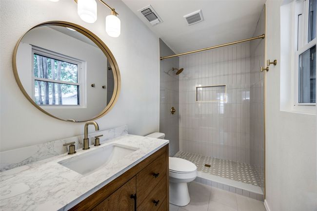 Full bath with vanity, a tile shower, and tile patterned flooring | Image 10