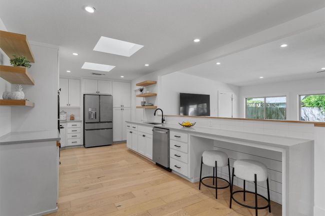 The kitchen features a quaint sitting area that is perfect for a quick meal or homework station. | Image 10