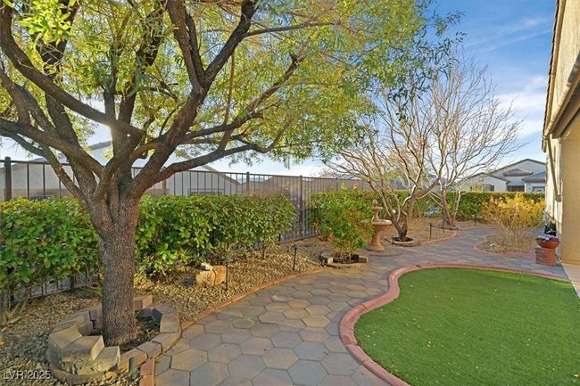 View of very private backyard featuring a patio area, relaxing fountain, mature trees and landscaping, and outstanding sunset views | Image 18