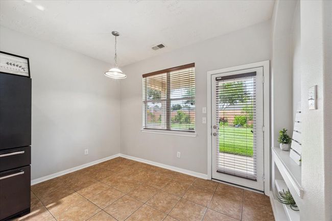 The breakfast area overlooking the patio and backyard. Windows featuring blinds. | Image 22