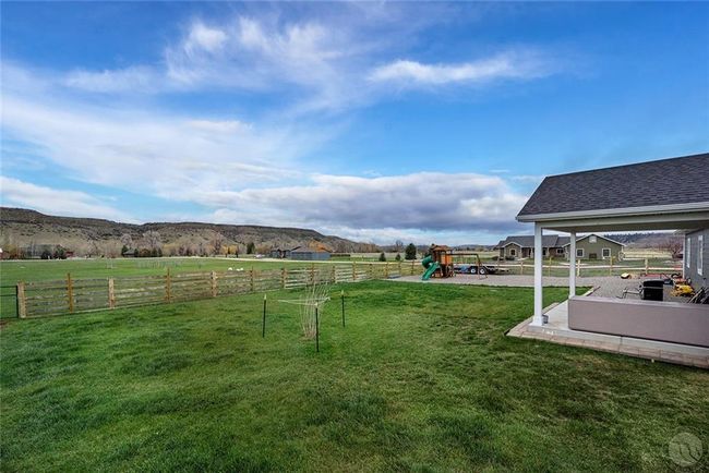 Partially fenced to keep the dogs in, covered back patio, pea graveled play yard. | Image 27