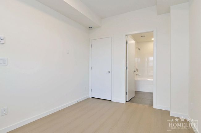 Unfurnished bedroom with baseboards, wood finished floors, and connected bathroom | Image 11