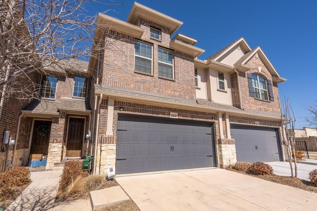 View of property with brick siding, an attached garage, and driveway | Image 23