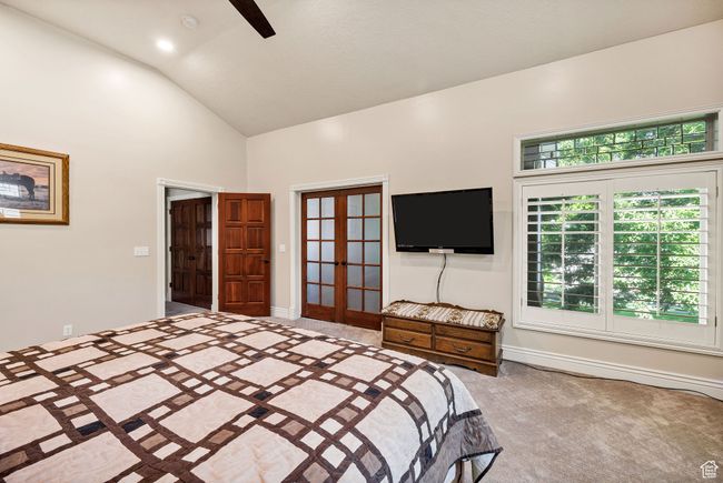 Carpeted bedroom featuring french doors, high vaulted ceiling, and ceiling fan | Image 33