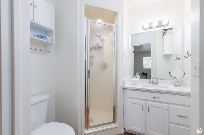 Full bath featuring vanity, a shower stall, and toilet | Image 15