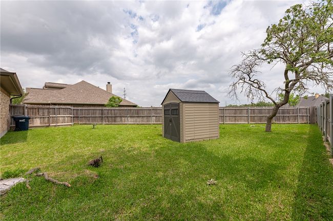 View of yard featuring a fenced backyard, a shed, and an outbuilding | Image 33