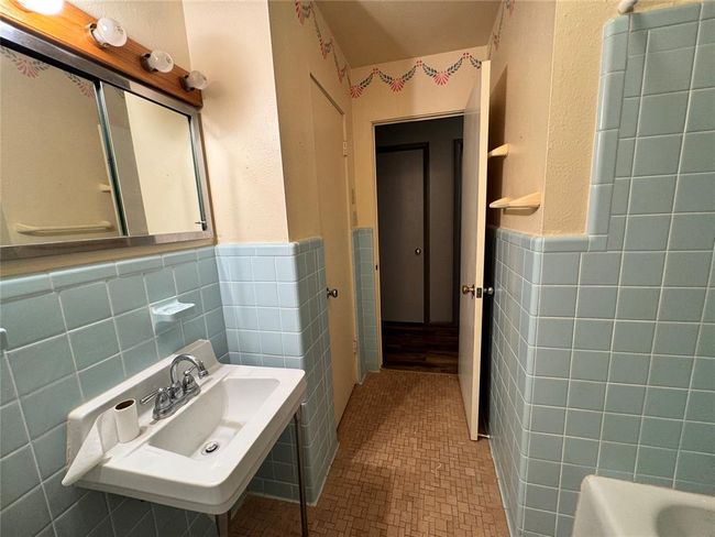 Bathroom featuring bathing tub / shower combination, tile walls, tasteful backsplash, and tile floors | Image 28