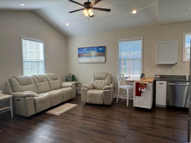 Living area featuring lofted ceiling, plenty of natural light, a ceiling fan, dark wood-style flooring, and recessed lighting | Image 7