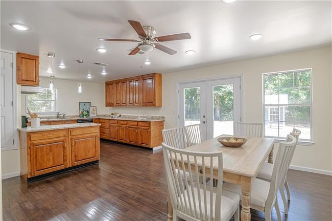 Dining room with dark wood-type flooring, ceiling fan, plenty of natural light, and french doors | Image 22