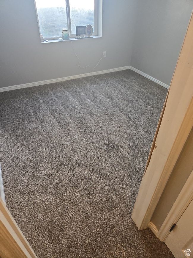 Spare room with baseboards and dark colored carpet | Image 29
