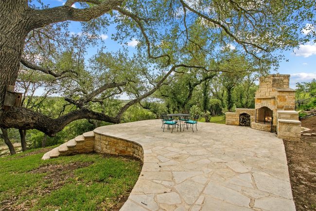 View of patio featuring an outdoor stone fireplace | Image 30
