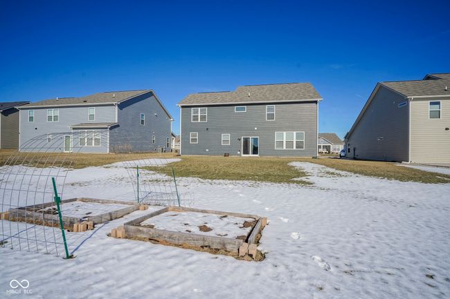 snow covered rear of property with a vegetable garden | Image 45