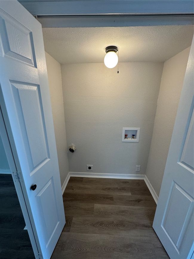 Washroom with washer hookup, dark wood-type flooring, baseboards, and hookup for an electric dryer | Image 16