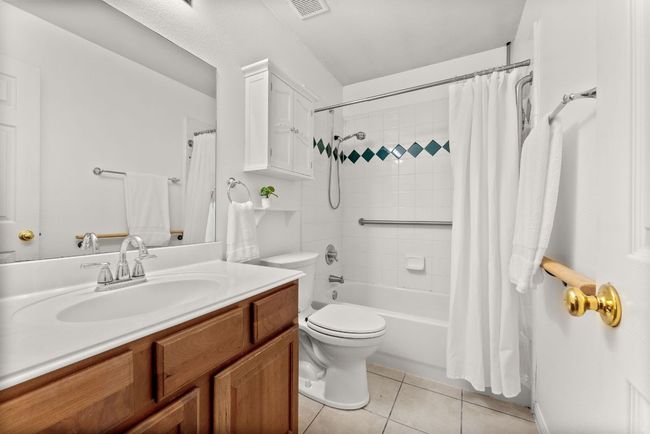 Bathroom featuring vanity, visible vents, shower / bath combination with curtain, toilet, and tile patterned floors | Image 26