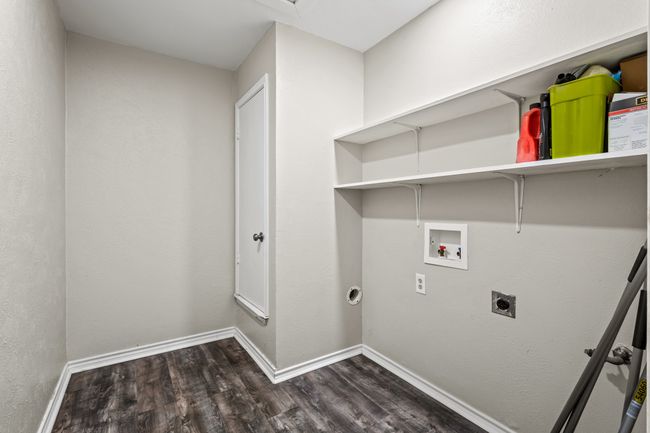 Washroom featuring hookup for an electric dryer, wood finished floors, hookup for a washing machine, and baseboards | Image 14
