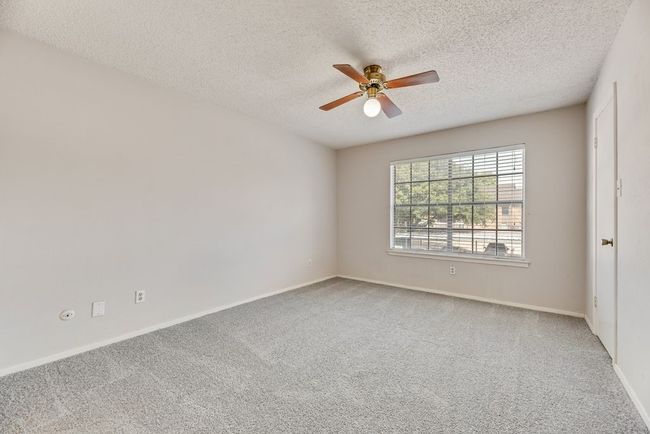 Carpeted spare room featuring a ceiling fan and a textured ceiling | Image 14