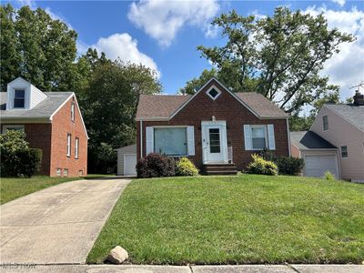 View of front facade with a front yard and a garage | Image 1