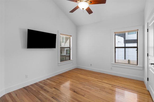 Empty room featuring light wood-type flooring, vaulted ceiling, baseboards, and a ceiling fan | Image 21