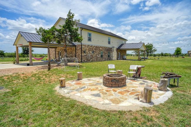 Back of home showing an area for family entertainment around the fire pit | Image 39