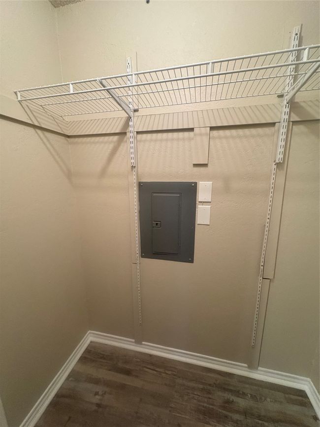 Walk in closet with electric panel and wood finished floors | Image 11