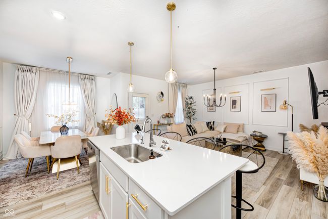 kitchen with a sink, a chandelier, a breakfast bar area, light wood-style flooring, and dishwasher | Image 12