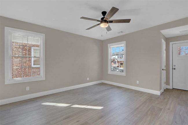 Empty room with light wood-style floors, visible vents, and baseboards | Image 10