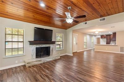 Living area with granite fireplace, unique plank wood ceiling. | Image 3