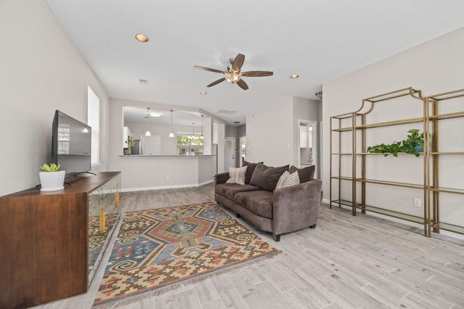 Living room with baseboards, recessed lighting, wood finished floors, and ceiling fan | Image 6