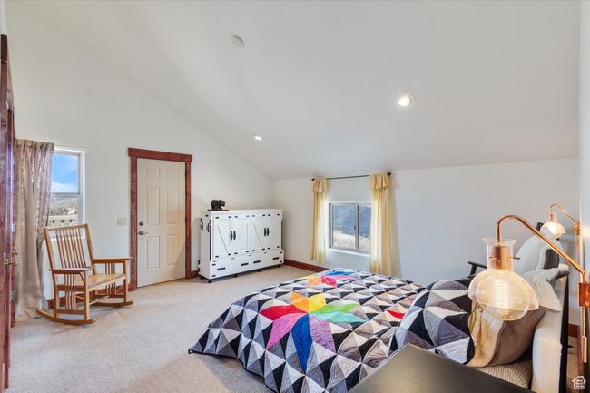 Bedroom featuring light colored carpet, vaulted ceiling, and recessed lighting | Image 10