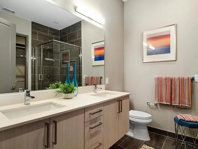 Full bathroom with radiator, visible vents, toilet, a stall shower, and a sink | Image 8