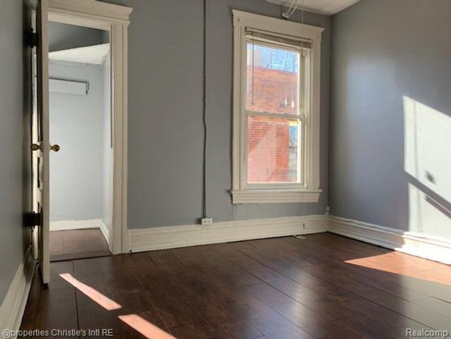 Unfurnished dining area with dark wood-type flooring and baseboards | Image 6
