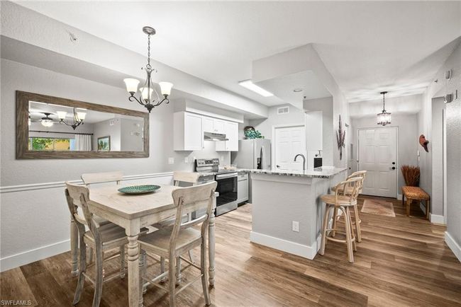 Dining area featuring baseboards, visible vents, wood finished floors, and an inviting chandelier | Image 7