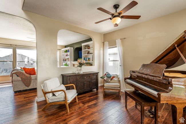 Sitting room with a ceiling fan, dark wood-style floors, baseboards, and arched walkways | Image 4