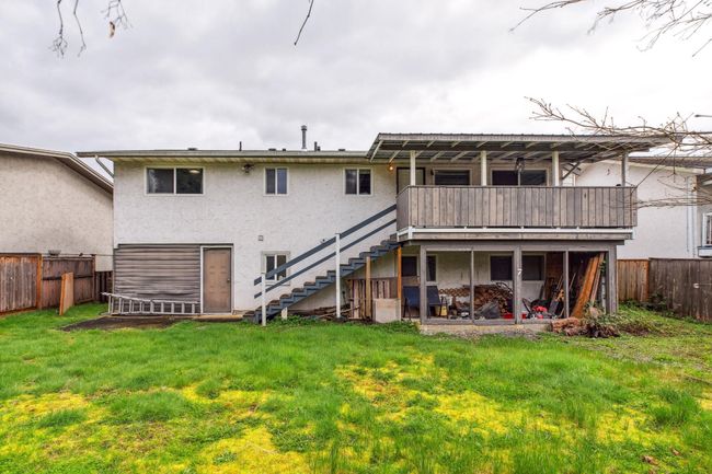 Back of house with a yard, fence, stucco siding, and stairs | Image 38